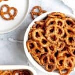 Homemade ranch pretzels on a plate, in a bowl, and in a pan.