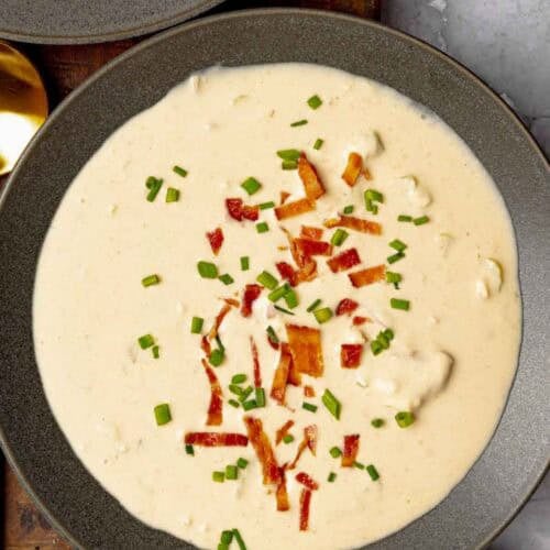 Cheese soup with beer and bacon garnished with bacon bits and chives.