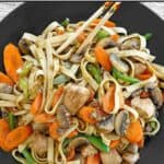 Marinated chicken, vegetables, and low mein noodles stir-fried and served.