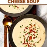Canadian cheese soup garnished with bacon bits and chives in two bowls.