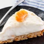 A slice of mandarin orange cheesecake with cookie crust.