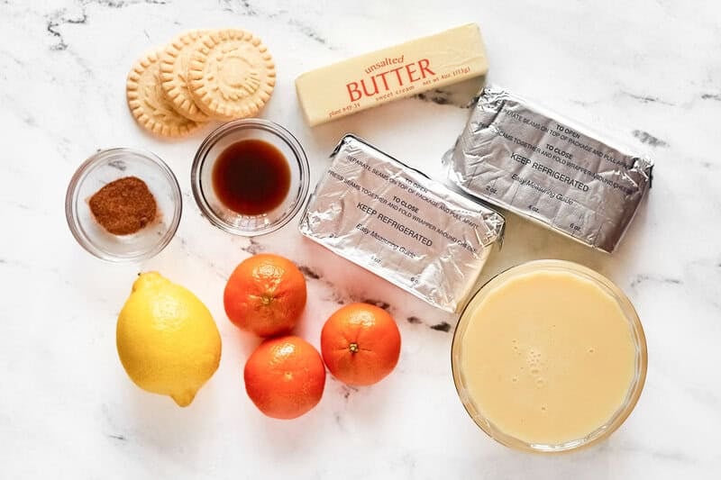 Mandarin oranges, cream cheese, sweetened condensed milk, butter, digestive cookies, nutmeg, and vanilla.