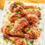 Baked and glazed chicken drumsticks served on a bed of white rice.