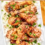 Glazed baked chicken drumsticks served over white rice.