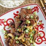 Mongolian beef with mushrooms garnished with green onions.