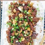 A platter of stir-fried Mongolian beef over white rice.