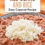 A bowl of red beans with rice on top.