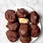 Chocolate peanut butter egg shaped candy piled on a plate.
