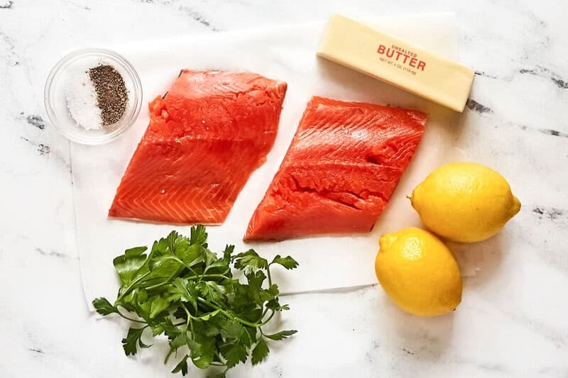 Raw salmon, butter, lemons, fresh parsley, salt, and pepper.