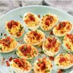 An appetizer of deviled eggs topped with candied bacon bits.