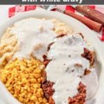 White gravy on southern chicken fried steak and mashed potatoes.