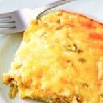 A serving of cheesy chili relleno casserole and a fork on a plate.