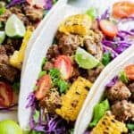Homemade ground beef tacos in soft shells and loaded with toppings.