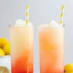 Copycat McDonald's frozen strawberry lemonade in two glasses and lemons by them.