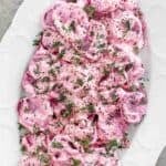 Polish roasted beets with sour cream dressing on a platter.