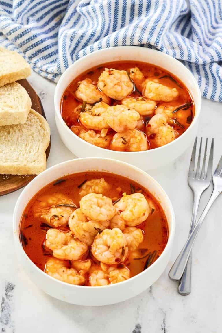 Shrimp served in a buttery herb tomato broth with bread.