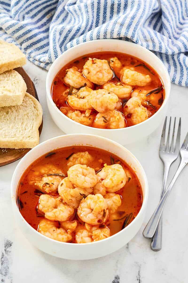 Shrimp served in a buttery herb tomato broth with bread.