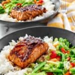 Stir-fried vegetables and grilled salmon with teriyaki sauce over rice.