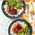 White rice topped with salmon and stir-fried veggies and teriyaki sauce.