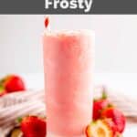 Copycat Wendy's strawberry frosty in a tall glass and fresh strawberries around it.