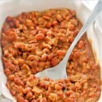 Homemade BBQ baked beans with bacon in a ceramic baking dish.