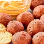 Copycat Captain D's hush puppies on a plate with dipping sauce.