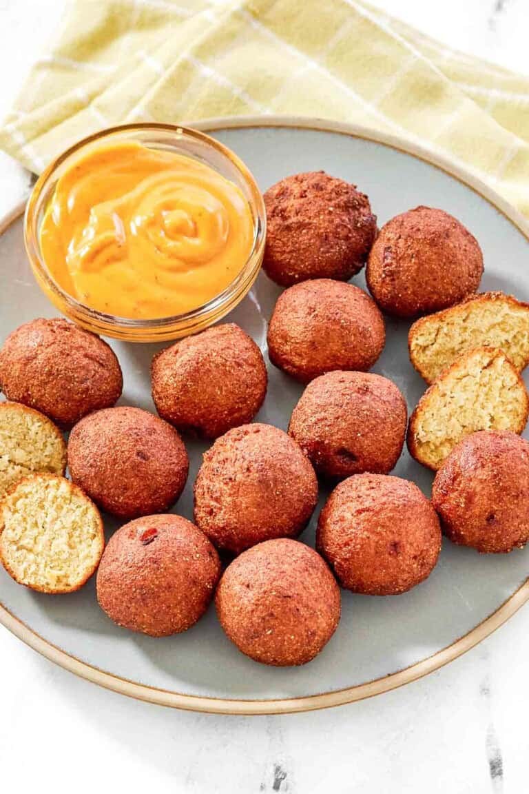 Fried cornbread hush puppy balls served with dipping sauce.