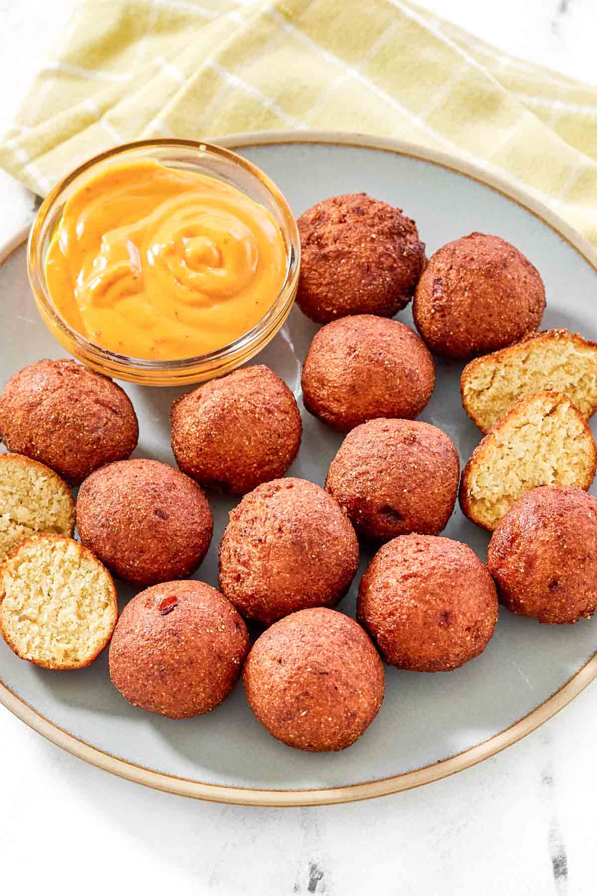 Fried cornbread hush puppy balls served with dipping sauce.