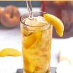 Copycat Olive Garden peach iced tea garnished with a peach slice.