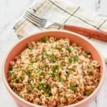 A bowl of copycat Popeyes Cajun Rice garnished with parsley.