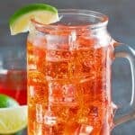 Homemade Sonic cherry limeade garnished with a lime wedge.