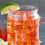 A glass of copycat Sonic cherry limeade garnished with a lime wedge.