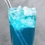Copycat Sonic ocean water drink in a tall glass with a straw on a marble surface.
