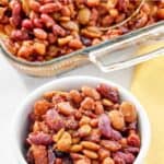 Baked beans quintet with bacon baked in a casserole dish and served in a bowl.