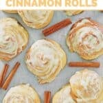 Copycat Cinnabon bread machine cinnamon rolls scattered on parchment paper.