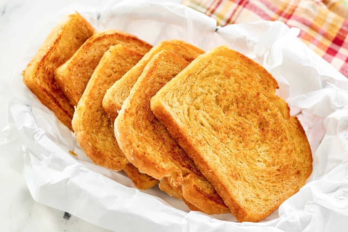 Slices of buttery garlic toast in a serving basket.