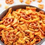 Homemade cheddar Chex mix with cheese crackers, cheese puffs, and pretzels.