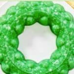 A creamy lime Jell-O salad with pineapple and cottage cheese made in a round mold.