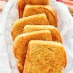 Crispy buttered garlic toast in a parchment paper lined serving basket.