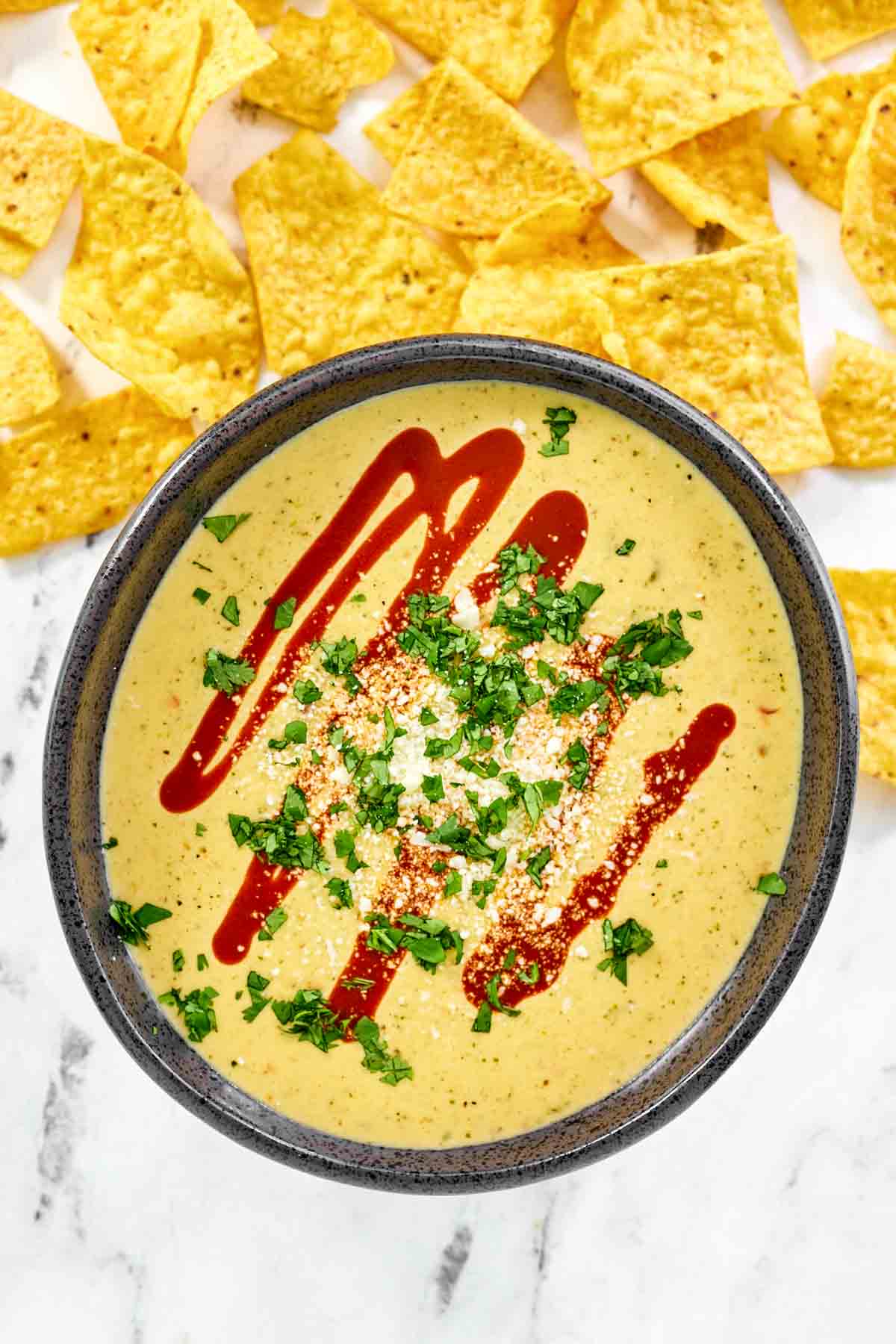 Green chile and tomatillo cheese dip served over guacamole.