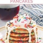 A stack of copycat IHOP cupcake pancakes with cream cheese icing and sprinkles.