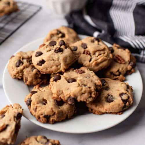 Chocolate chip cookies with nuts on a plate.