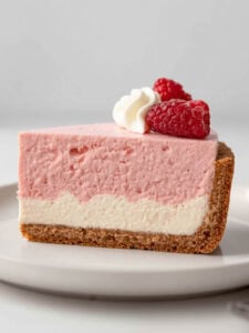 Layered cheesecake with raspberry mousse and graham cracker crust.