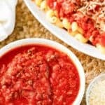 Copycat Olive Garden three meat sauce in a bowl and over pasta.