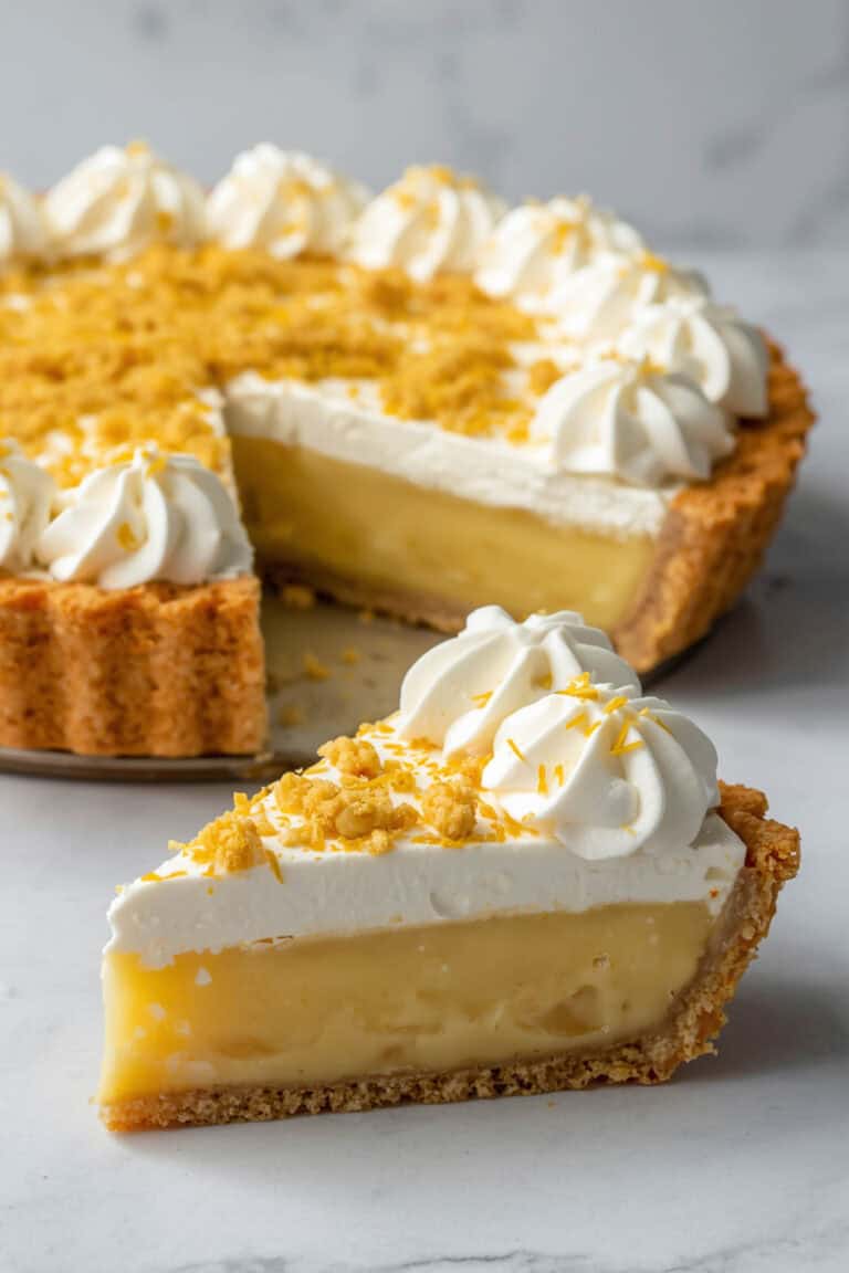 Lemon ice box pie with cake crust topped with whipped cream and cake crumbles.