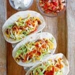 Ground beef soft tacos topped with lettuce, tomato, cheese, and copycat Taco Bell taco sauce.