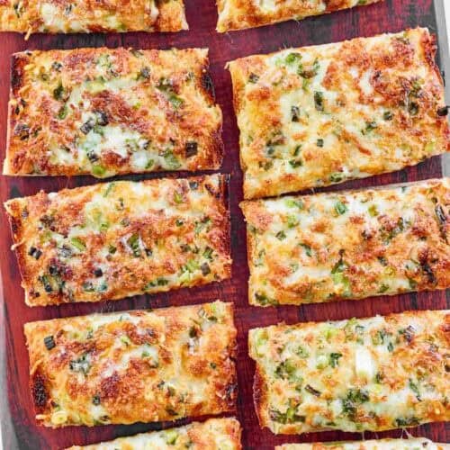 Baked green onion, garlic, and cheese French bread slices.