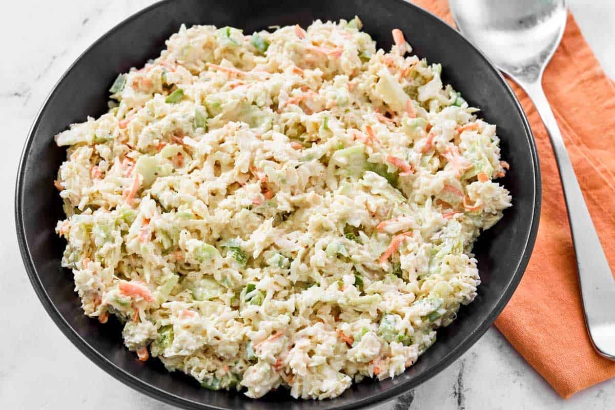 Creamy cabbage, carrot, onion, and bell pepper coleslaw in a bowl.