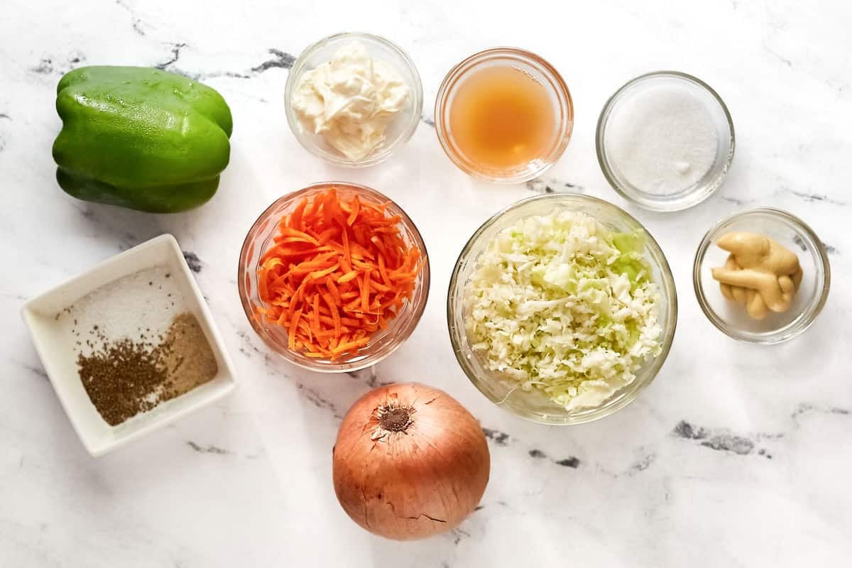 Cabbage, carrots, bell pepper, onion, mayonnaise, vinegar, and seasonings.