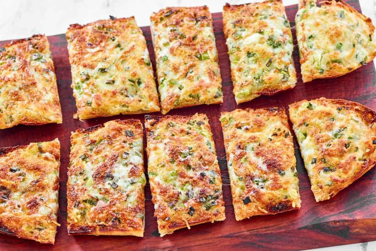 Cheese, garlic, and green onion bread slices.